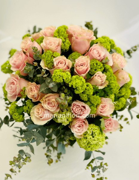 Mazzo d rose rosa e viburnium con verdi decorativi